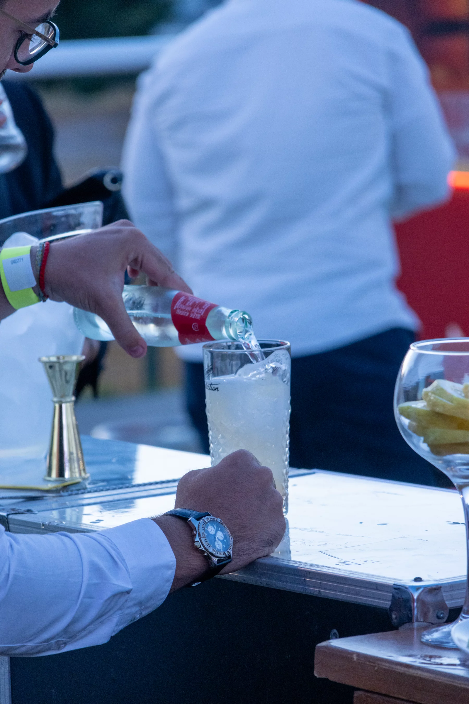 Camarero sirviendo un combinado con una botella de Schweppes sobre hielo en Amarilla Night