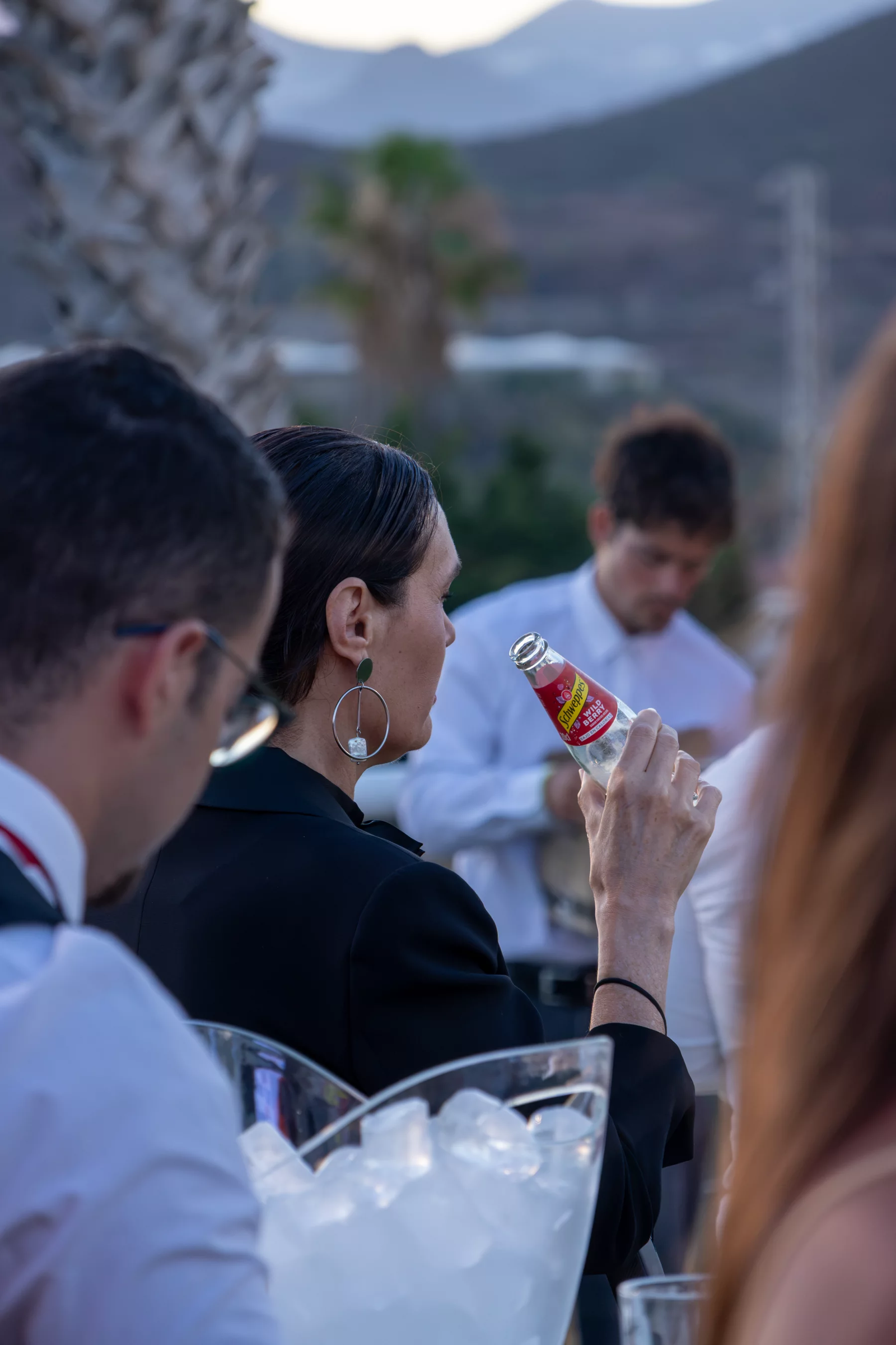 Invitados al atardecer en Amarilla Golf, una de ellas bebiendo de una botella de Schweppes