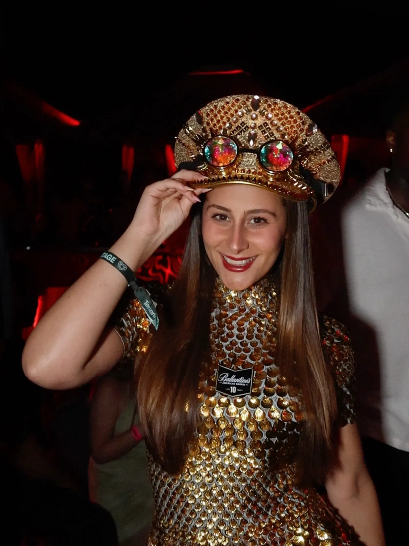 Invitada con gorra dorada y gafas de caleidoscopio sonriendo en la fiesta de Ballantine's en Tenerife
