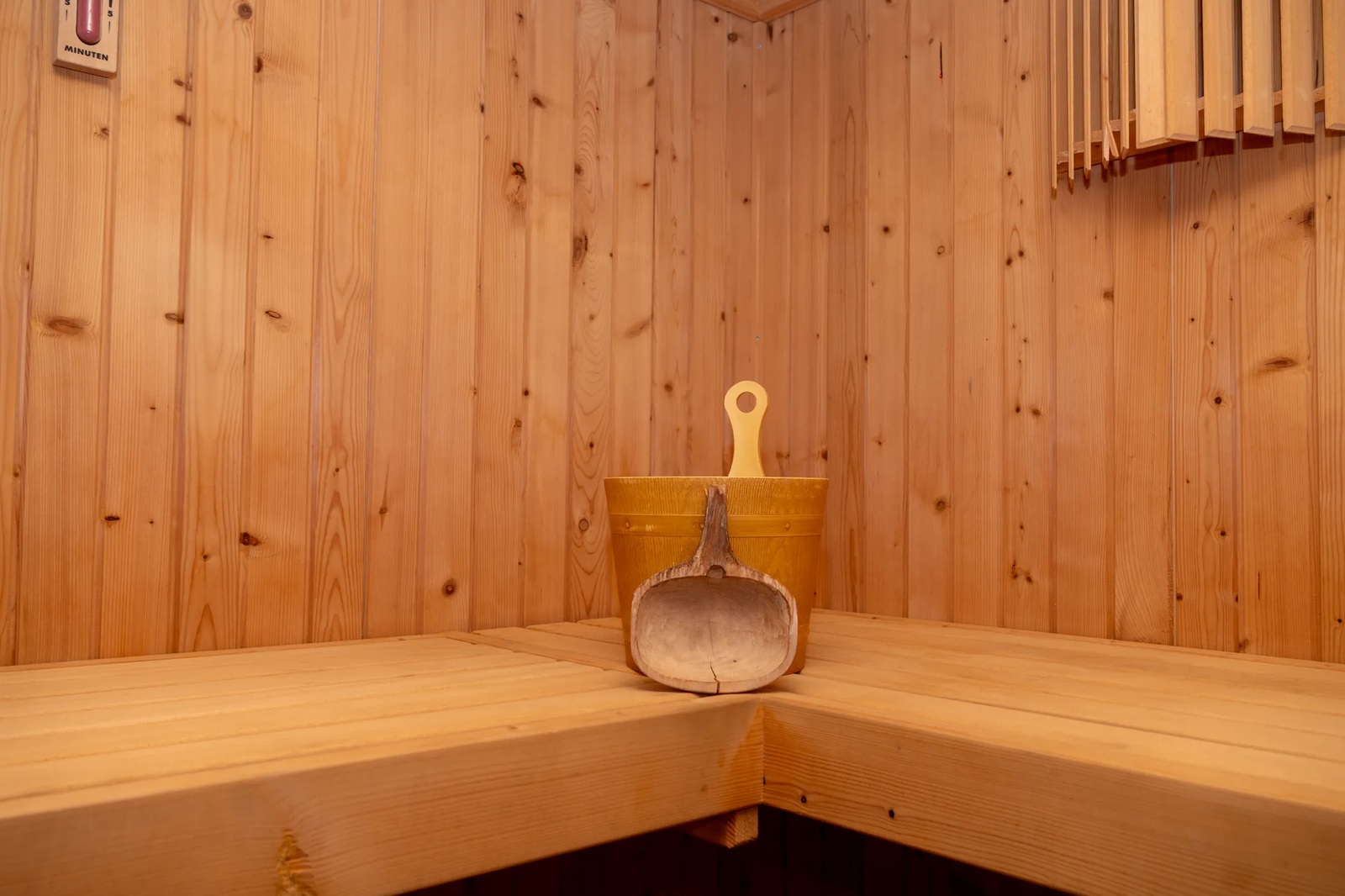 Sauna de madera con cubo y cazo en la zona de bienestar de Finca Viñas