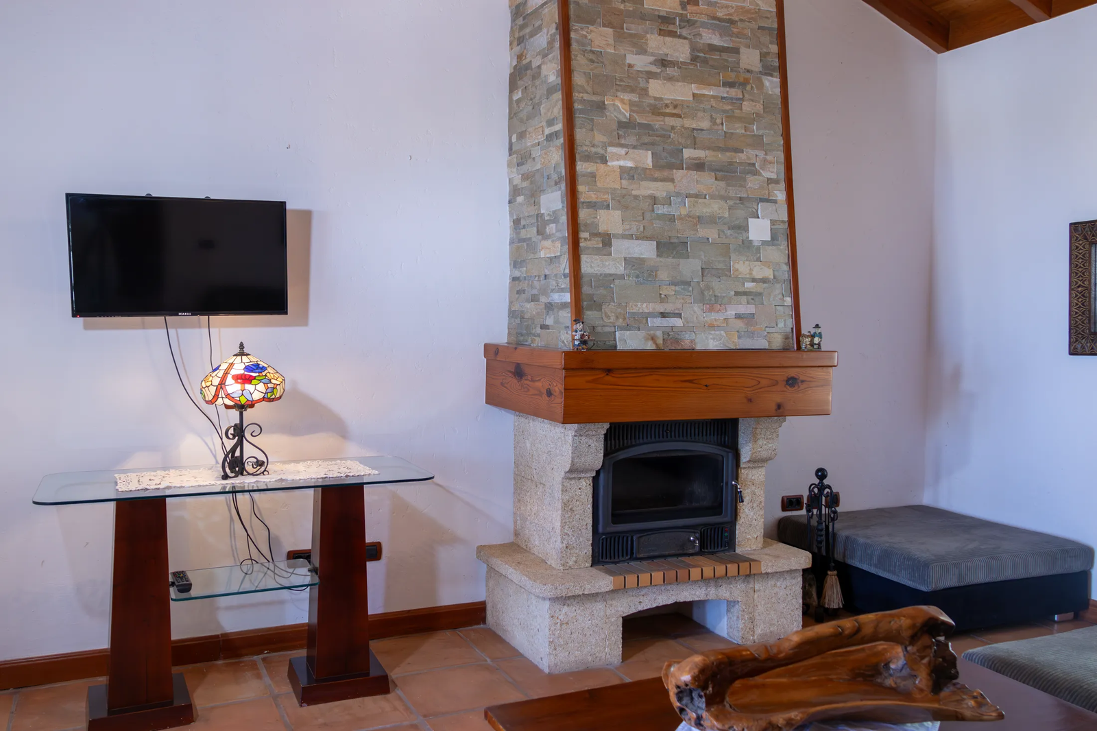 Salón con chimenea de piedra en una vivienda de Finca Viñas