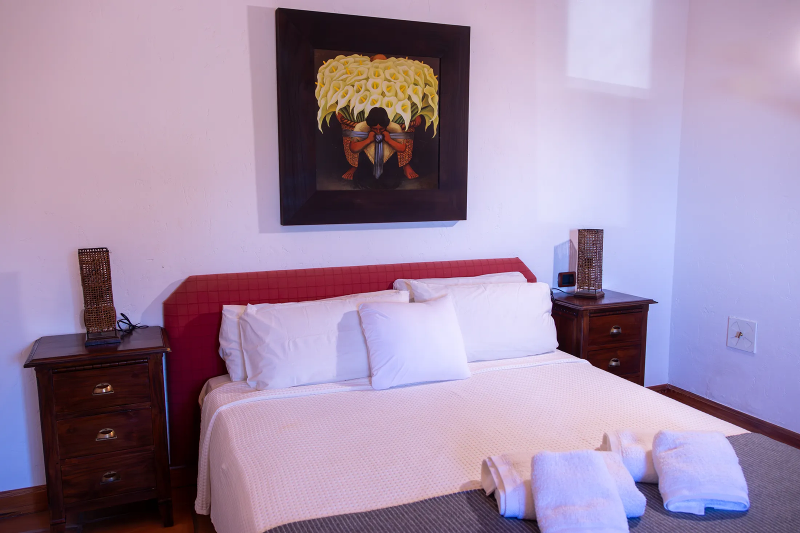 Dormitorio con cama de matrimonio, toallas dobladas y un cuadro en la pared en Finca Viñas