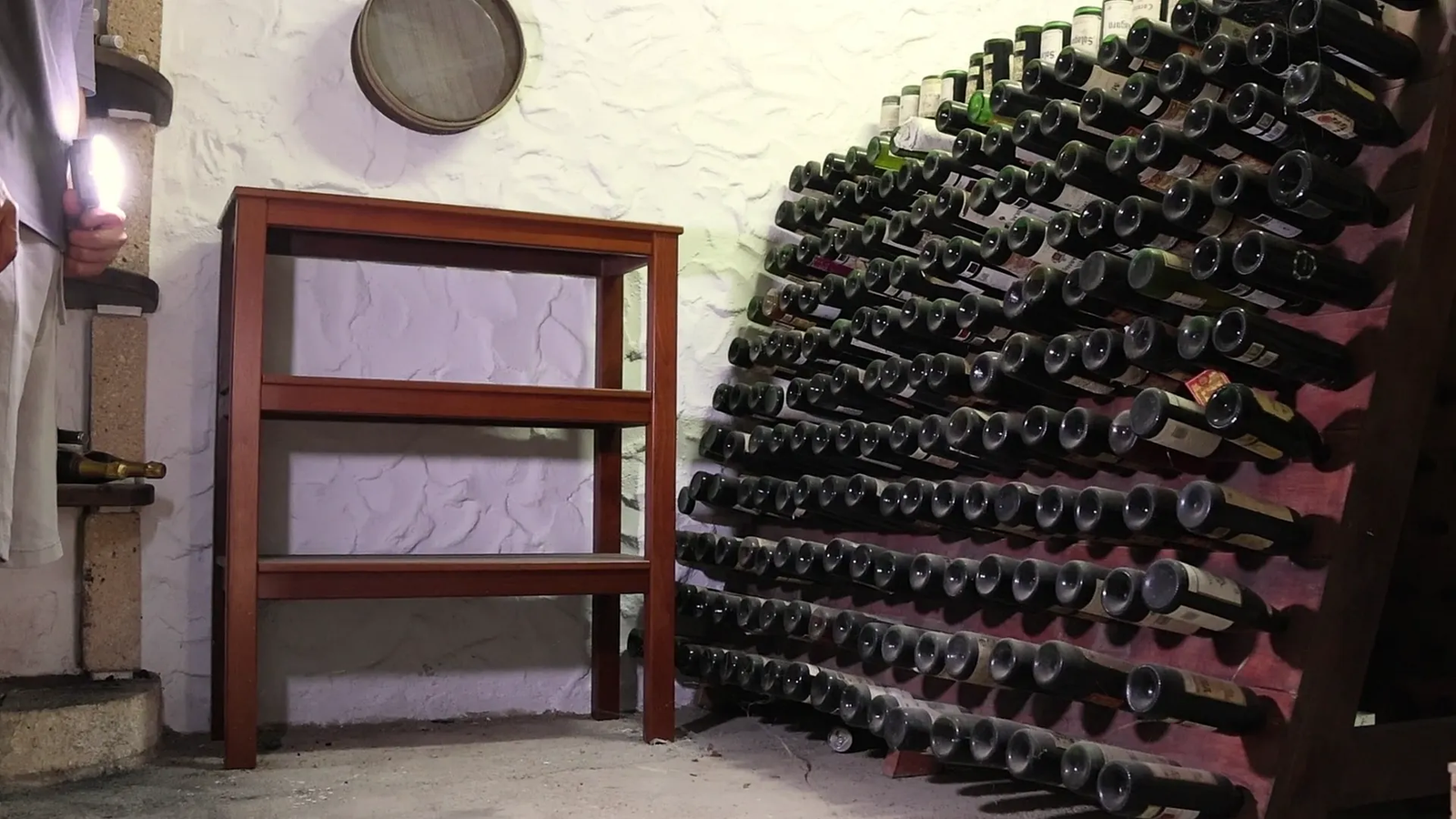 Botellero de obra lleno de vino en la bodega de Finca Viñas
